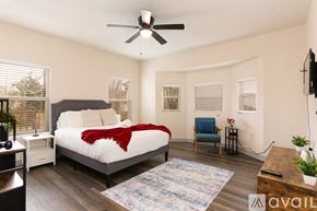 San Antonio house for rent - A bedroom with a bed, a chair, and a ceiling fan.