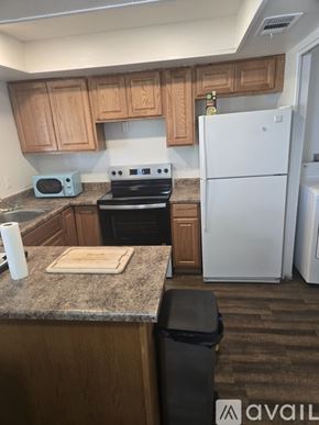 Phoenix condo for rent - A kitchen with a white refrigerator, wooden cabinets, and a granite countertop.