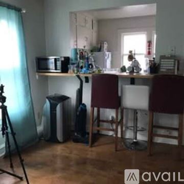 Appleton apartment for rent - A kitchen with a microwave, a fridge, a stove, a dining table with chairs and a tripod.