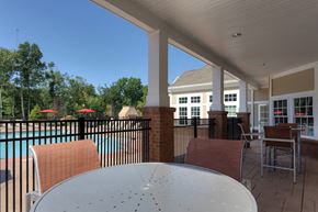 Farmington apartment for rent - a patio with a table and chairs and a swimming pool