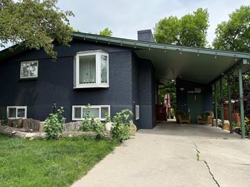 Louisville house for rent - A blue house with a white window and a green door.