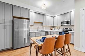 Flagstaff apartment for rent - A kitchen with a table and chairs in front of a refrigerator.