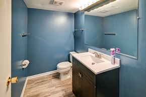 Madison house for rent - A bathroom with blue walls and a white toilet.