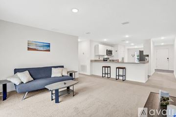 Palm Coast house for rent - A living room with a blue couch and a painting on the wall.