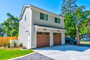 Charleston apartment for rent - A two-car garage is attached to a white house.