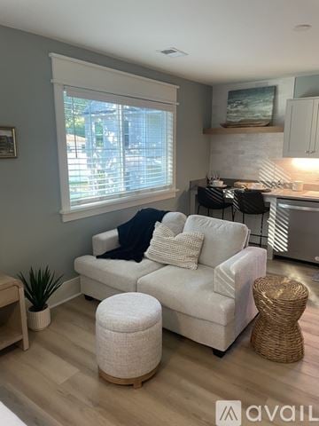 Charleston apartment for rent - A living room with a white couch and a wicker ottoman.