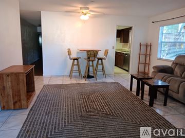 Daytona Beach apartment for rent - A living room with a brown rug and a wooden cabinet.