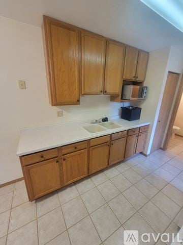 La Crosse apartment for rent - A kitchen with wooden cabinets and a white countertop.