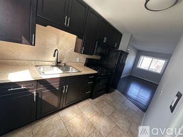 Wheaton apartment for rent - A kitchen with black cabinets and a tiled floor.