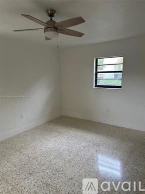 Miami house for rent - A room with a ceiling fan and a window.