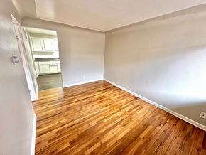 Lakewood apartment for rent - A room with wooden flooring and a kitchen visible through the door.
