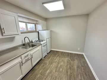 Lakewood apartment for rent - A kitchen with white cabinets and a wood floor.