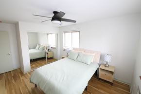 Denver apartment for rent - A bedroom with a bed, nightstand, and mirror.