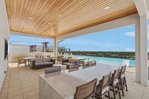 Cape Coral apartment for rent - A modern outdoor dining area with a view of the pool and beach.