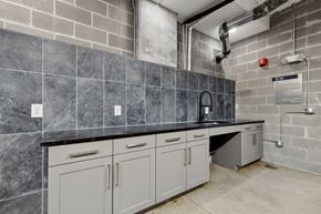 Irving apartment for rent - A kitchen with grey cabinets and a black countertop.