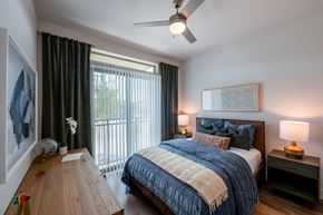 Irving apartment for rent - A bedroom with a bed, nightstand, and a painting on the wall.
