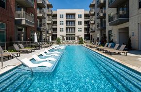 Irving apartment for rent - A long rectangular pool with lounge chairs on either side.