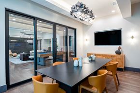 Irving apartment for rent - A modern dining room with a black table and yellow chairs.