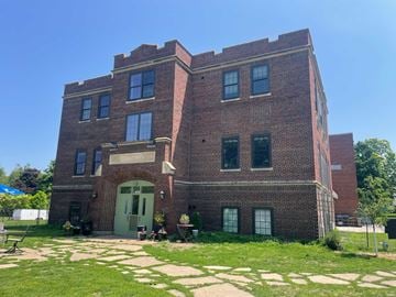 Menomonie apartment for rent - A red brick building with a green door and windows.