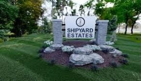 Marinette apartment for rent - A sign for Shipyard Estates is surrounded by rocks and flowers.