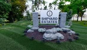 Marinette apartment for rent - A sign for Shipyard Estates is surrounded by rocks and flowers.