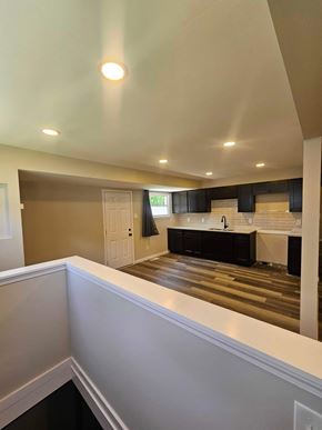 St Louis house for rent - A well-lit kitchen with dark wood floors and white walls.