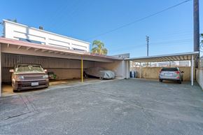 No. Hollywood apartment for rent - A parking lot with two cars and a building in the background.