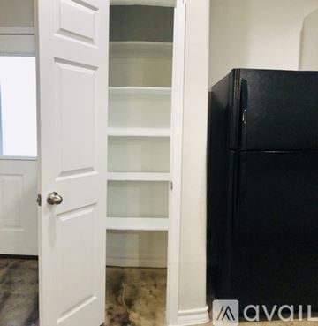 Selma townhouse for rent - A black refrigerator is in a kitchen next to a white door.