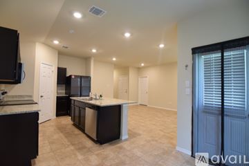 Killeen house for rent - A kitchen with black cabinets and a countertop with a sink.