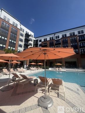 Tampa apartment for rent - A swimming pool surrounded by palm trees and apartment buildings.