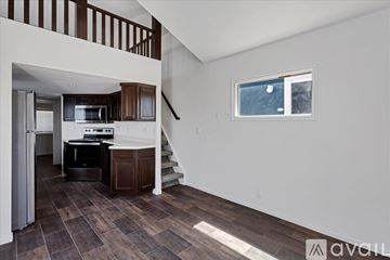 Barstow apartment for rent - A kitchen with a refrigerator, microwave, and oven is in a house with a staircase.