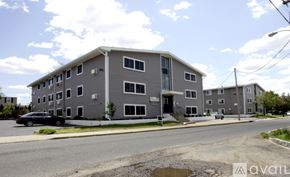 Keansburg apartment for rent - A grey apartment building with a black car parked in front.