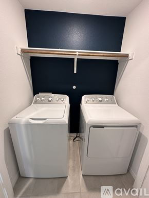 Fort Worth house for rent - Two white front load washing machines in a small laundry room.