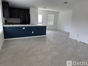 Fort Worth house for rent - A kitchen with a dark blue island and light grey tiled floor.