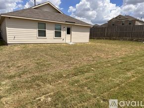 Fort Worth house for rent - A small house with a brown roof and a white door is surrounded by a grassy area.