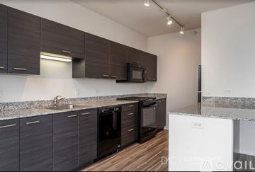 Chicago apartment for rent - A kitchen with dark brown cabinets and a white counter.