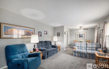 Omaha house for rent - A living room with a blue chair and a grey sofa.