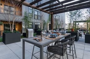 Columbus apartment for rent - A patio with a table and chairs is set up outside a building.