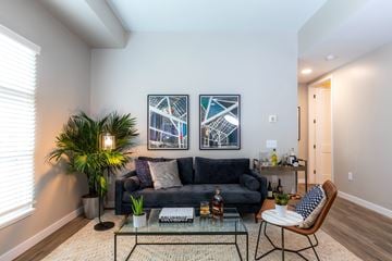 Columbus apartment for rent - A living room with a black couch and a glass coffee table.