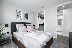 Columbus apartment for rent - A bedroom with a large bed and a mirror on the wall.