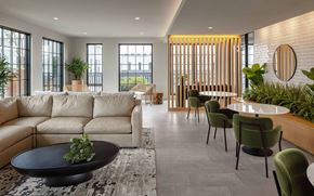 Columbus apartment for rent - A conference room with a long table and chairs, a painting on the wall, and a view of the outside through large windows.
