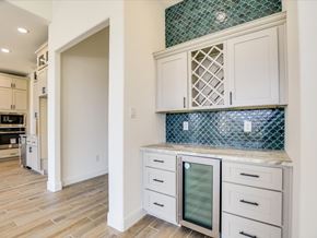 Horseshoe Bay house for rent - A kitchen with white cabinets and a green backsplash.