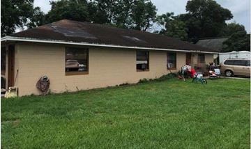 Orlando apartment for rent - A house with a brown roof and a white wall with a hose hanging on it.