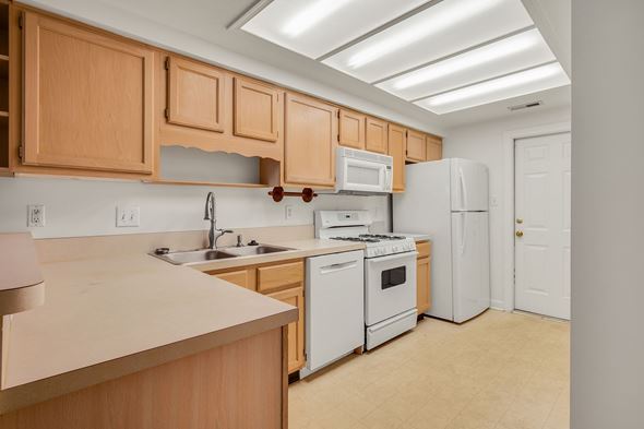Glen Allen house for rent - A kitchen with white appliances and wooden cabinets.