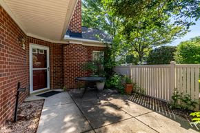 Glen Allen house for rent - A red brick house with a white fence and a small garden.