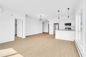 Edmonton apartment for rent - A spacious, empty room with wooden floors and white walls.
