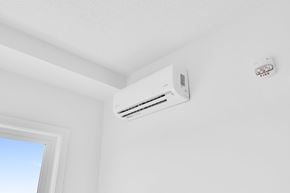 Edmonton apartment for rent - A white air conditioner is mounted on a white wall next to a window.