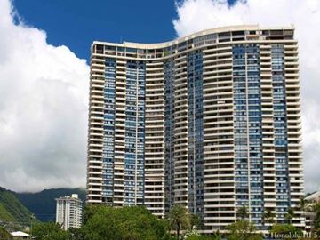 Honolulu apartment for rent - A large building with many windows is in front of a mountain.