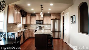 Smithfield house for rent - A kitchen with wooden cabinets and a black island.