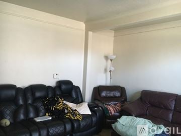 Ypsilanti apartment for rent - A living room with a black leather sofa and a brown leather chair.